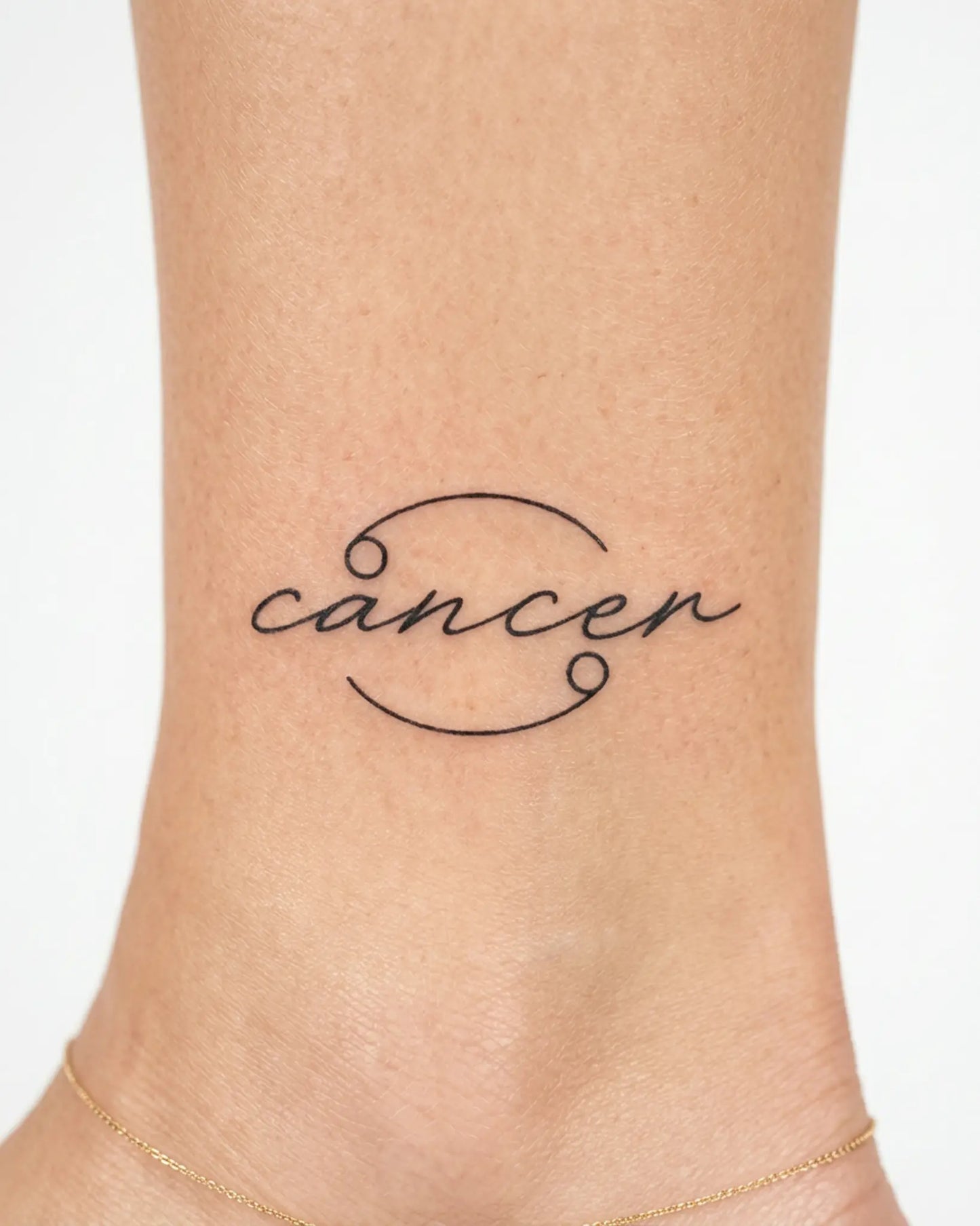 INKY Cancer Script semi-permanent tattoo applied on a woman – 2 x 2 in (4x4 cm) design, realistic ink look, lasts 10 days