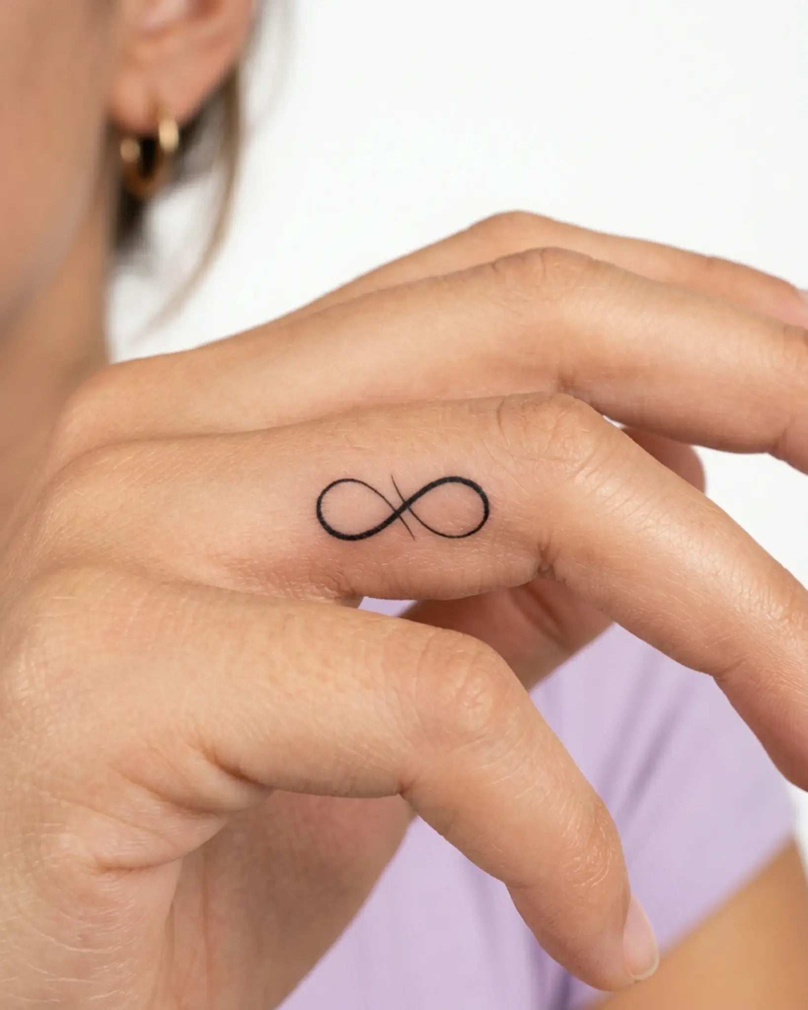 INKY Infinity Flow semi-permanent tattoo applied on a woman – 0.5 x 0.5 in (1x1 cm) design, realistic ink look, lasts 10 days