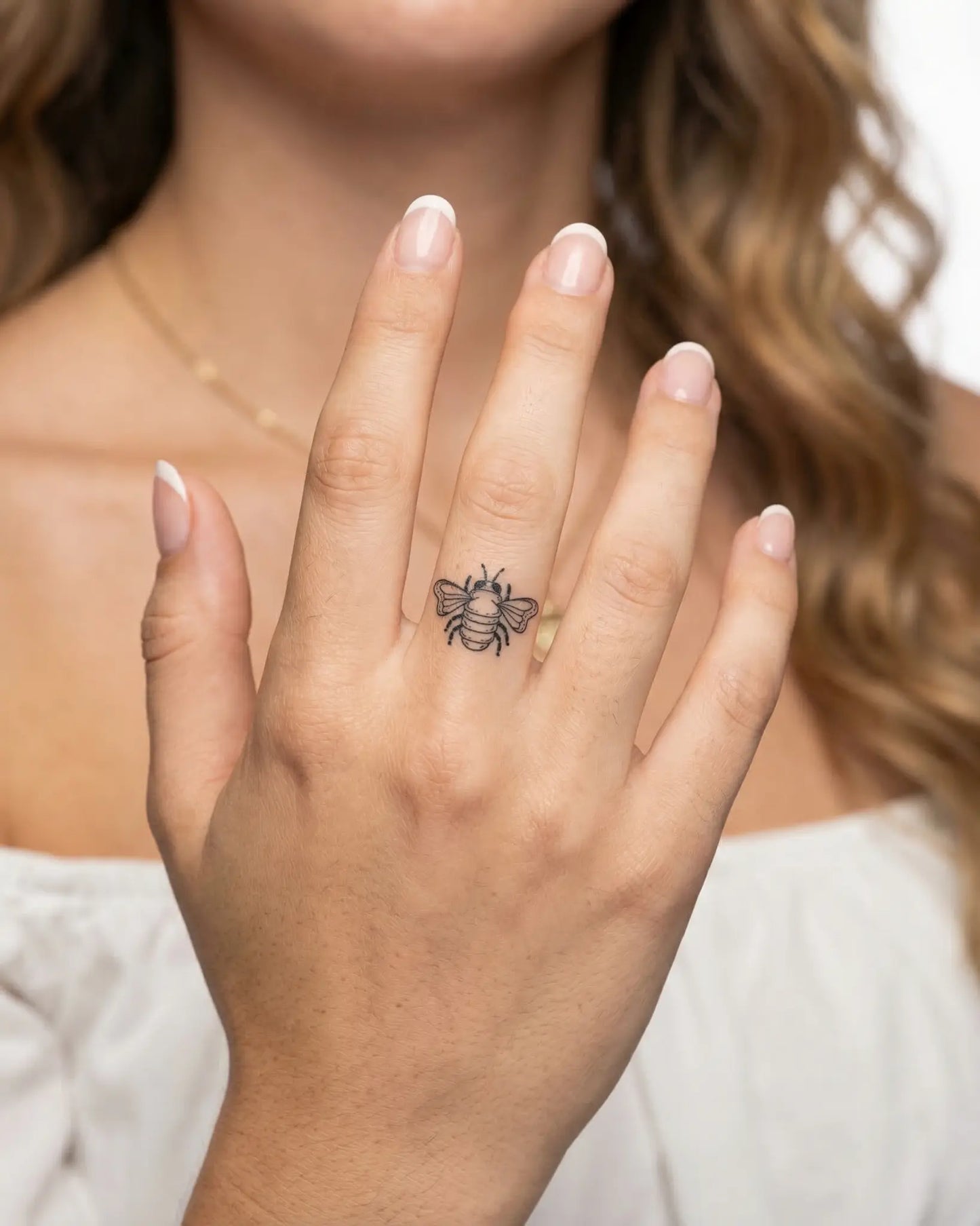 INKY Buzz Bee 2 semi-permanent tattoo applied on a woman – 0.5 x 0.5 in (1x1 cm) design, realistic ink look, lasts 10 days