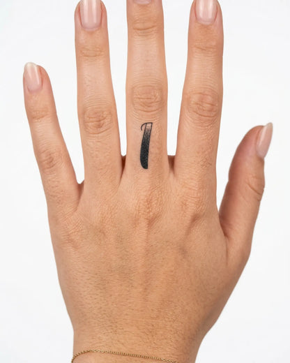 INKY Script 1 semi-permanent tattoo applied on a woman – 0.5 x 0.5 in (1x1 cm) design, realistic ink look, lasts 10 days