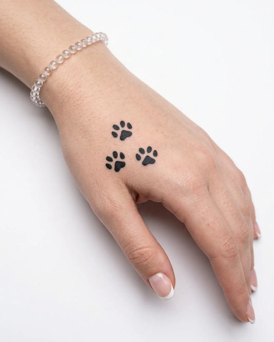 INKY Paw Prints semi-permanent tattoo applied on a woman – 2 x 2 in (4x4 cm) design, realistic ink look, lasts 10 days