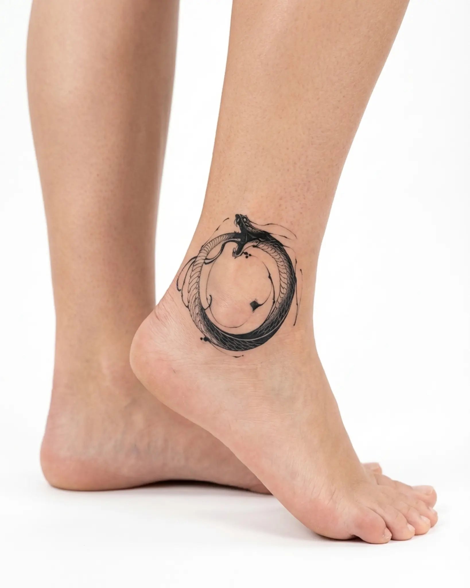 INKY Ouroboros semi-permanent tattoo applied on a woman – 2 x 2 in (4x4 cm) design, realistic ink look, lasts 10 days