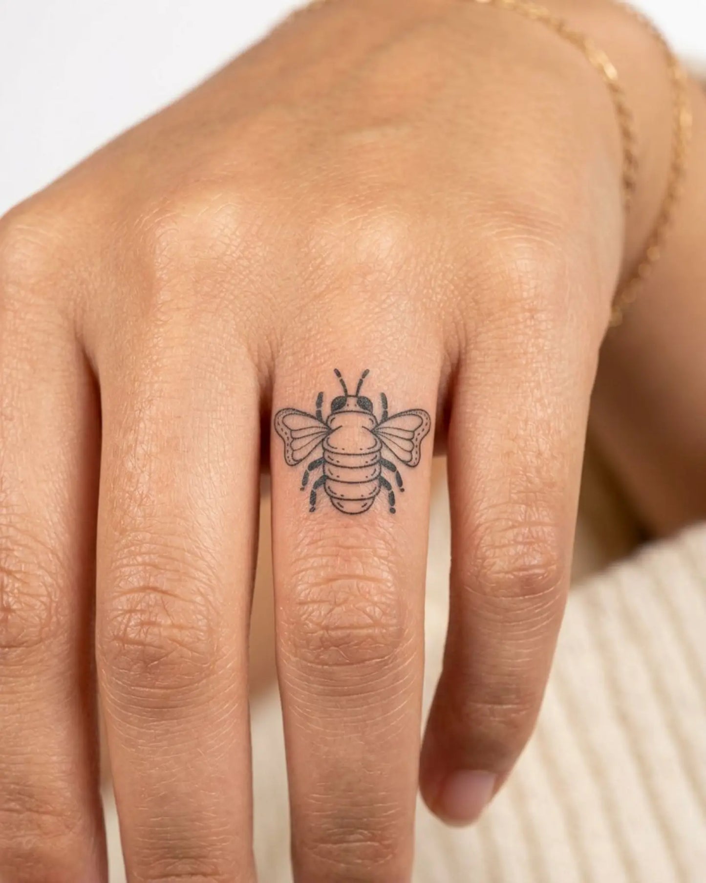 INKY Little Bee semi-permanent tattoo applied on a woman – 0.5 x 0.5 in (1x1 cm) design, realistic ink look, lasts 10 days