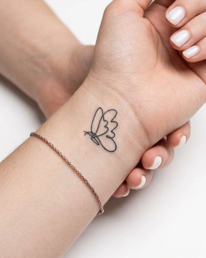 INKY Linefly semi-permanent tattoo applied on a woman – 2 x 2 in (4x4 cm) design, realistic ink look, lasts 10 days