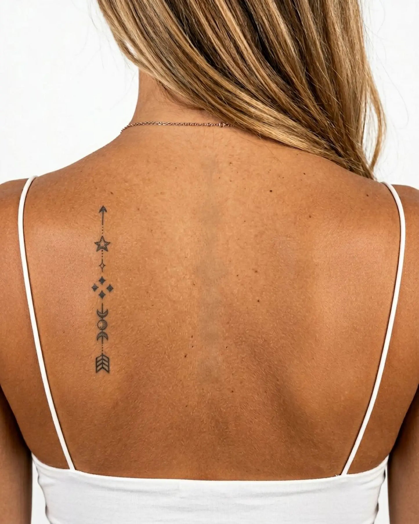 INKY Cosmic Arrow semi-permanent tattoo applied on a woman – 2 x 4 in (6x10 cm) design, realistic ink look, lasts 10 days
