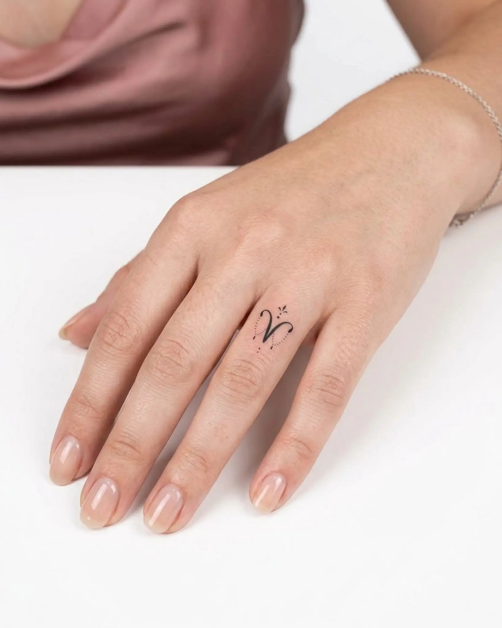 INKY Aries Charm 2 semi-permanent tattoo applied on a woman – 0.5 x 0.5 in (1x1 cm) design, realistic ink look, lasts 10 days