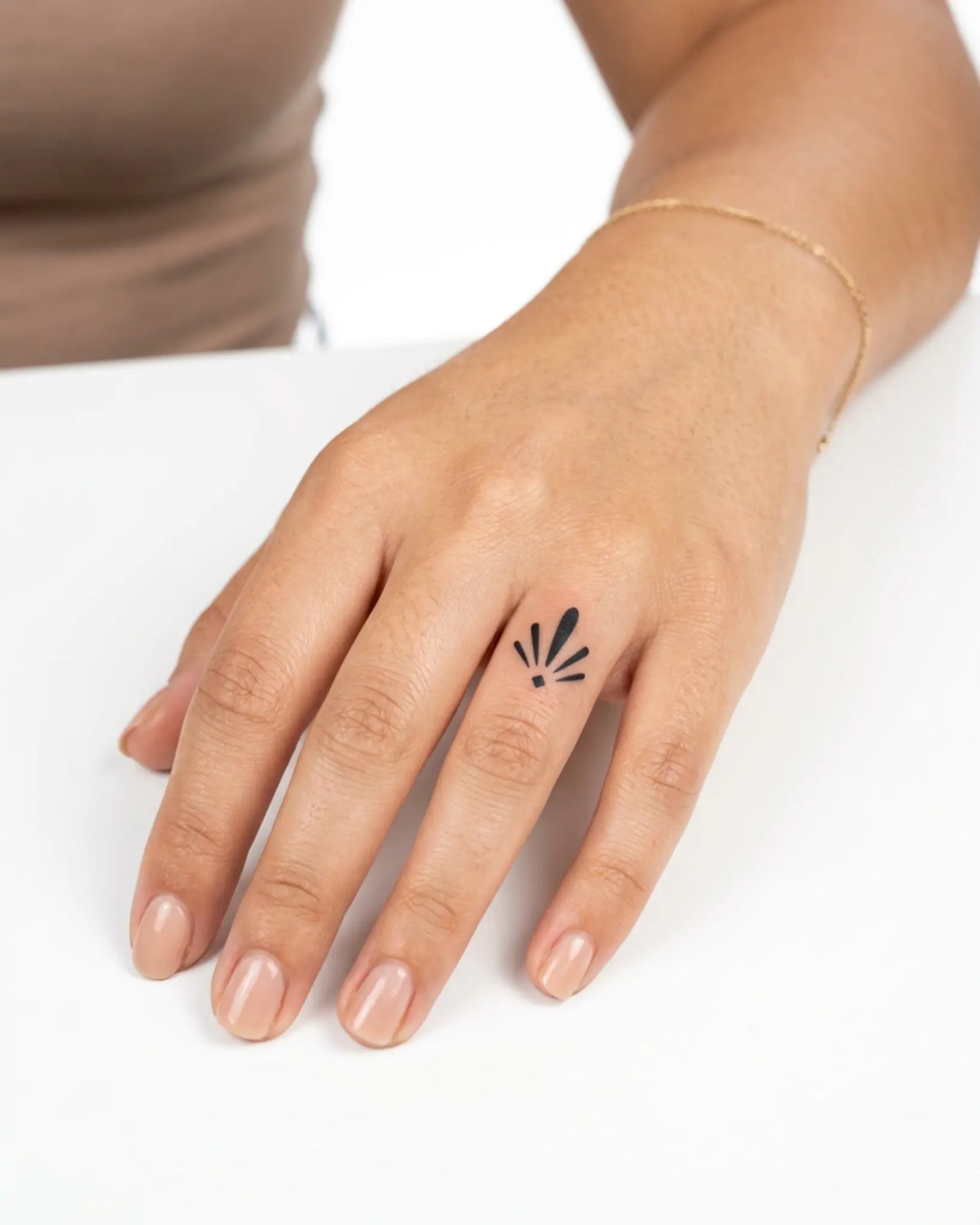 INKY Art Deco Burs semi-permanent tattoo applied on a woman – 0.5 x 0.5 in (1x1 cm) design, realistic ink look, lasts 10 days