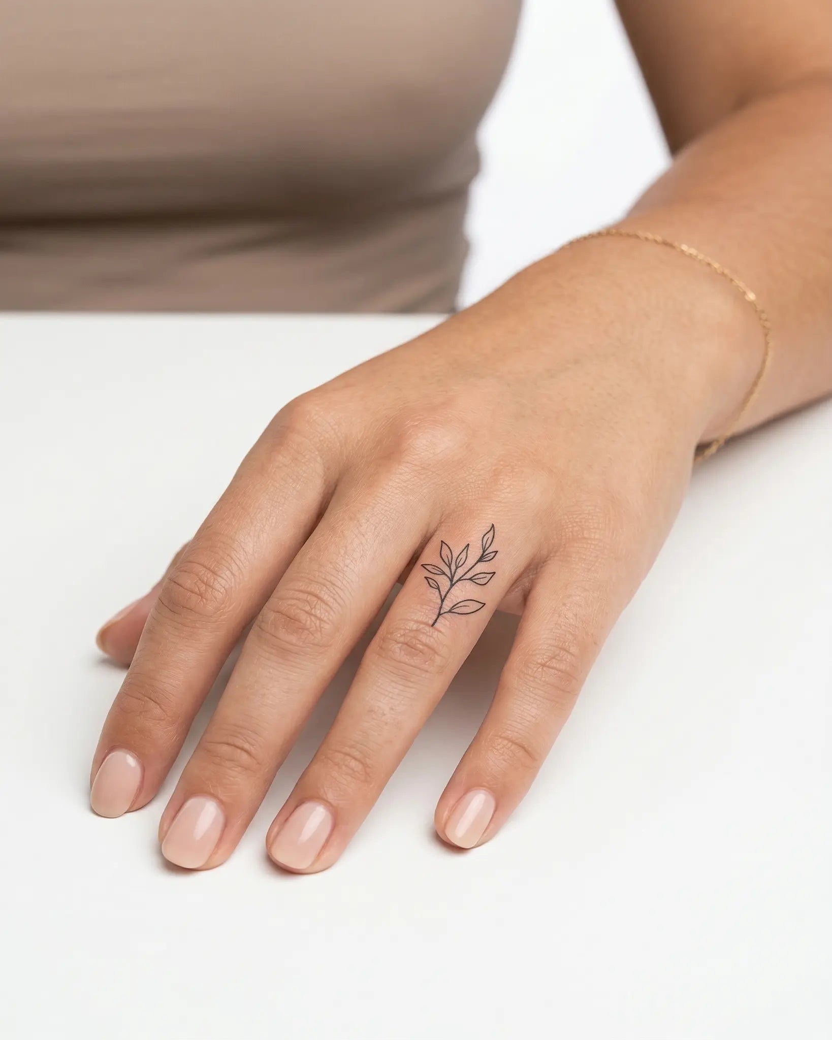INKY Leafy Sprig semi-permanent tattoo applied on a woman – 0.5 x 0.5 in (1x1 cm) design, realistic ink look, lasts 10 days