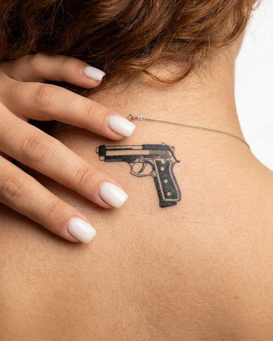INKY Handgun semi-permanent tattoo applied on a woman – 2 x 2 in (4x4 cm) design, realistic ink look, lasts 10 days