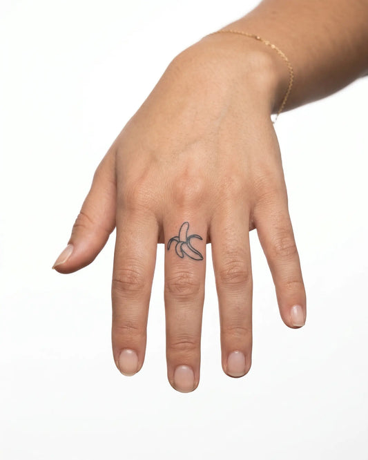 INKY Peeled Banana semi-permanent tattoo applied on a woman – 0.5 x 0.5 in (1x1 cm) design, realistic ink look, lasts 10 days