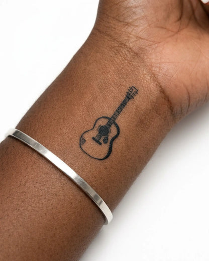 INKY Guitar Doodle semi-permanent tattoo applied on a woman – 2 x 2 in (4x4 cm) design, realistic ink look, lasts 10 days