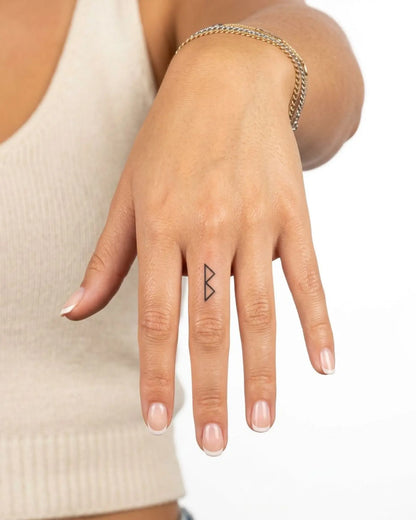 INKY Berkana Rune 2 semi-permanent tattoo applied on a woman – 0.5 x 0.5 in (1x1 cm) design, realistic ink look, lasts 10 days