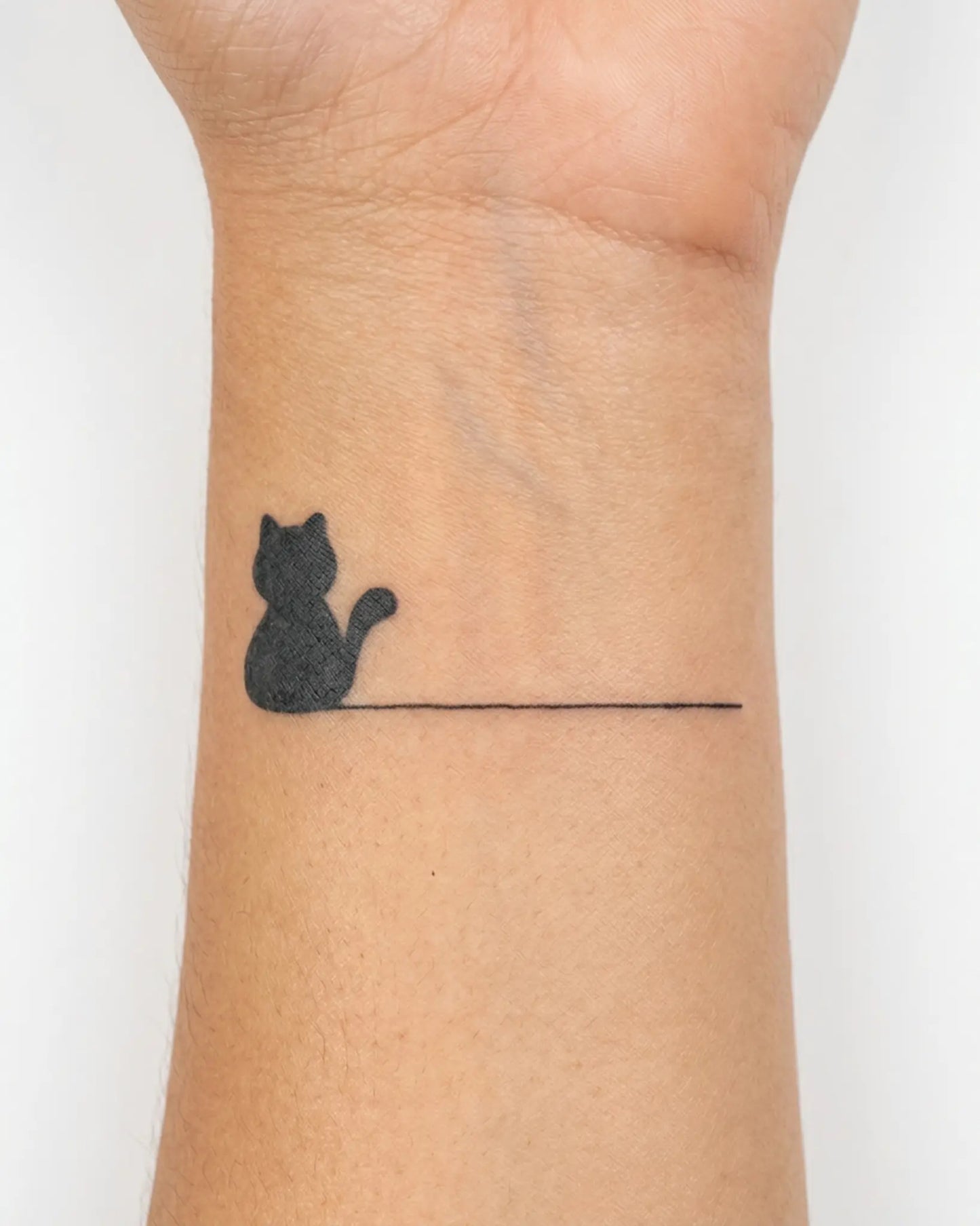INKY Minimal Cat semi-permanent tattoo applied on a woman – 2 x 2 in (4x4 cm) design, realistic ink look, lasts 10 days