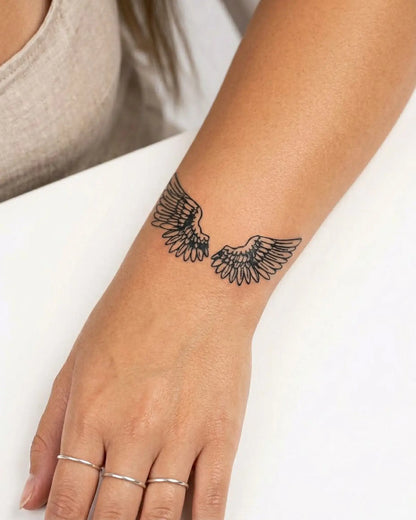 INKY Angel Wings semi-permanent tattoo applied on a woman – 2 x 2 in (4x4 cm) design, realistic ink look, lasts 10 days