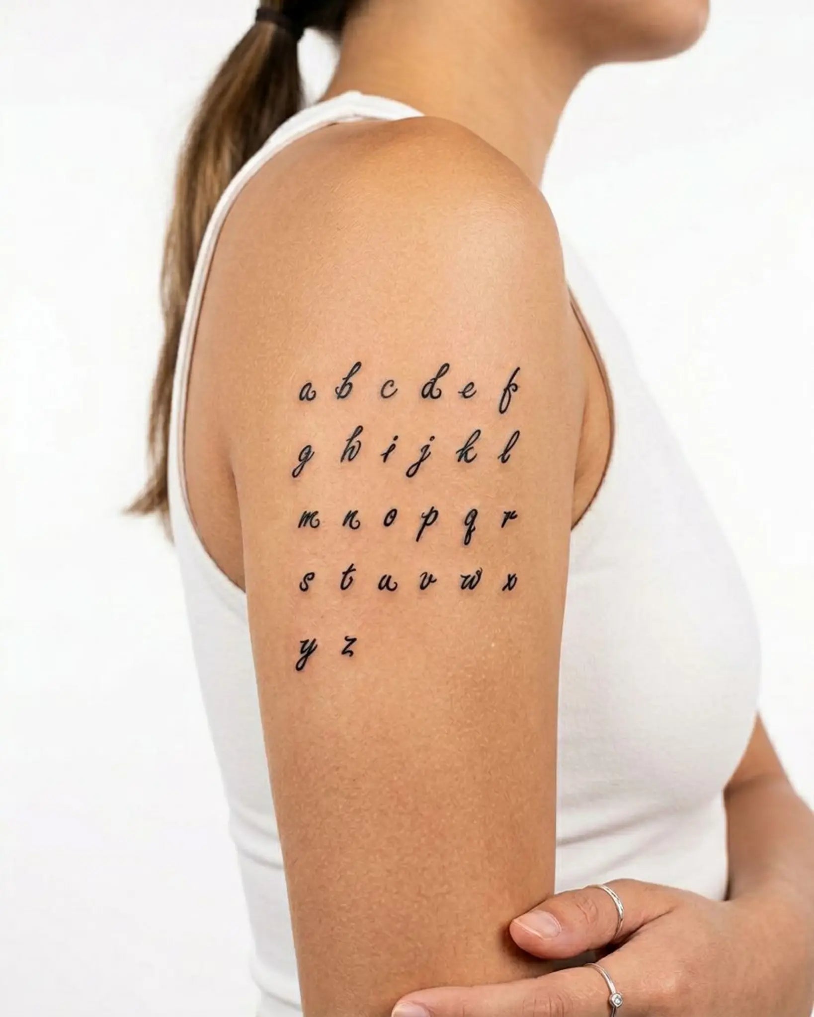 INKY ABC Script semi-permanent tattoo applied on a woman – 3 x 3 in (7x7 cm) design, realistic ink look, lasts 10 days