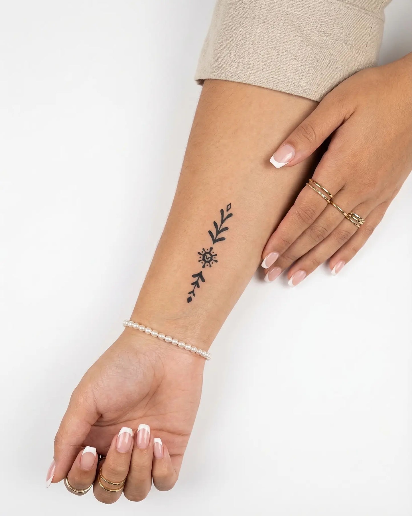 INKY Sun Glyph semi-permanent tattoo applied on a woman – 2 x 4 in (6x10 cm) design, realistic ink look, lasts 10 days