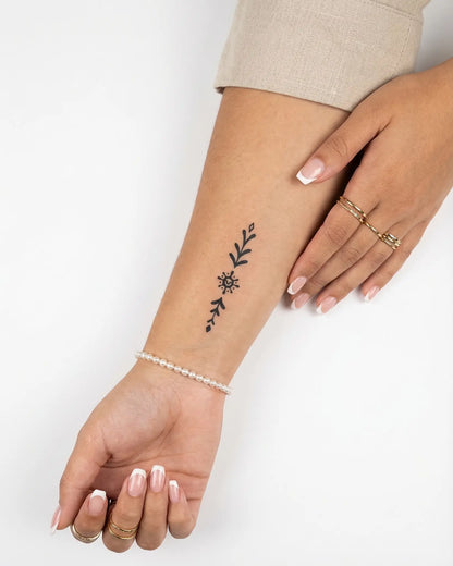 INKY Sun Glyph semi-permanent tattoo applied on a woman – 2 x 4 in (6x10 cm) design, realistic ink look, lasts 10 days