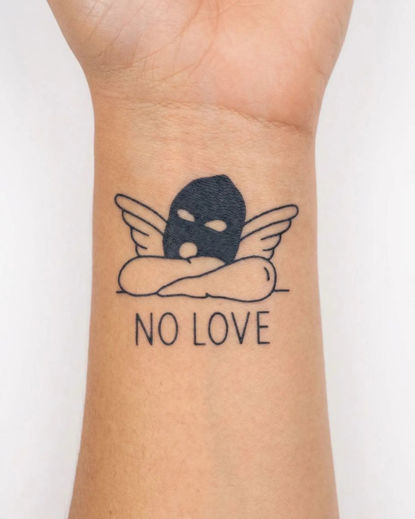 INKY Angel No Love semi-permanent tattoo applied on a woman – 2 x 2 in (4x4 cm) design, realistic ink look, lasts 10 days