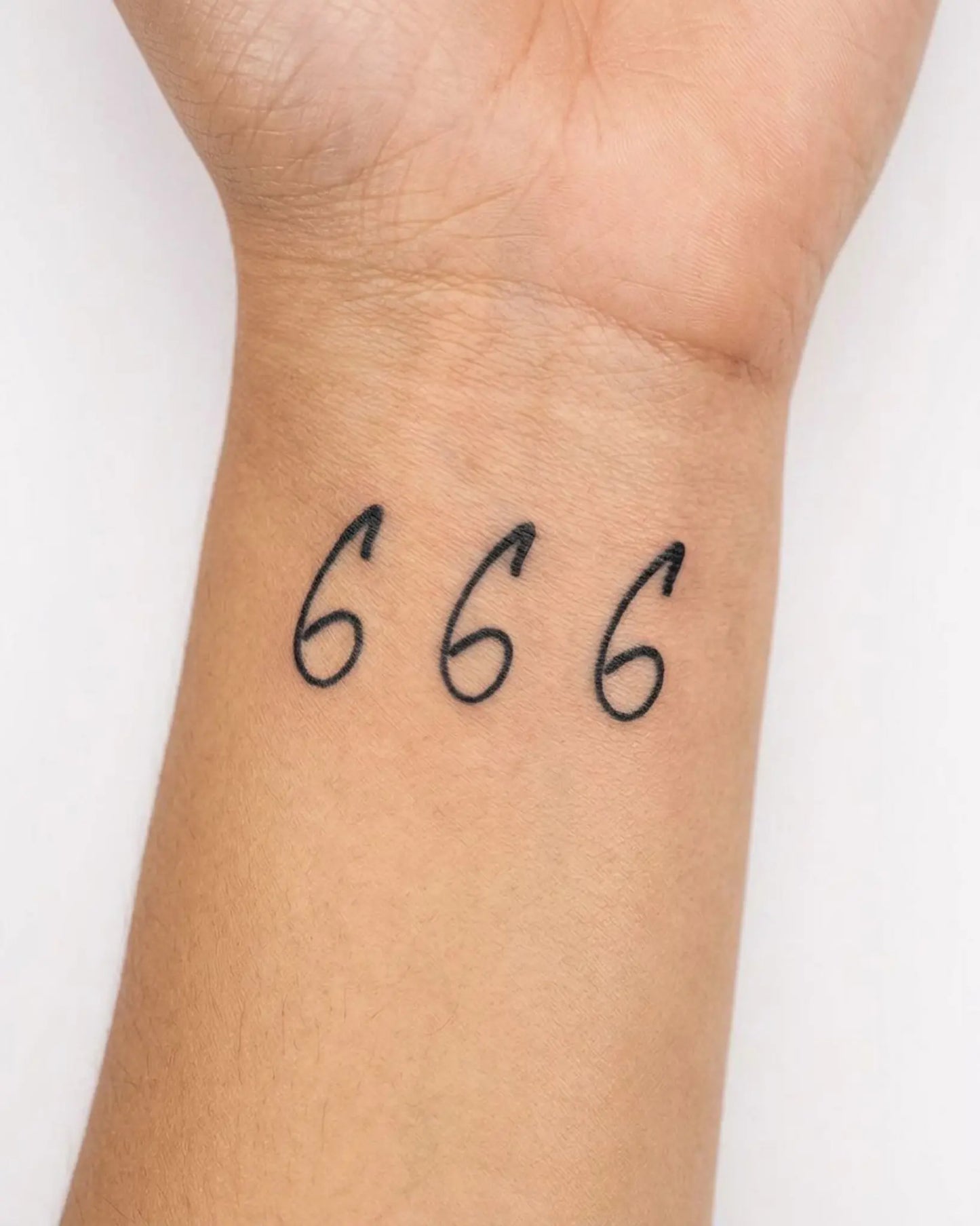 INKY Cursive 666 semi-permanent tattoo applied on a woman – 2 x 2 in (4x4 cm) design, realistic ink look, lasts 10 days