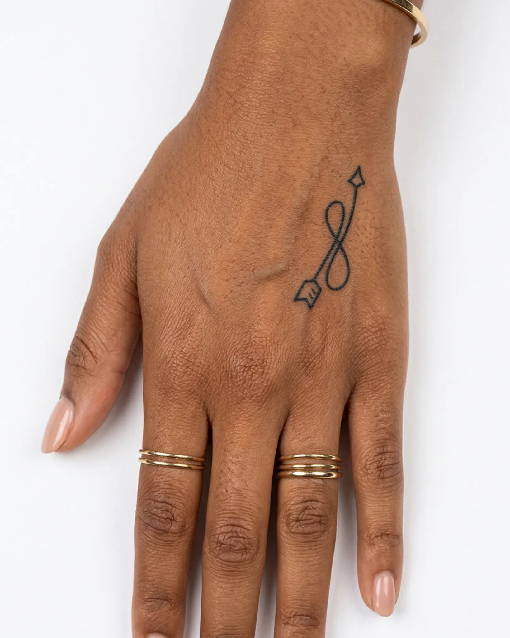 INKY Loop Arrow 2 semi-permanent tattoo applied on a woman – 2 x 2 in (4x4 cm) design, realistic ink look, lasts 10 days