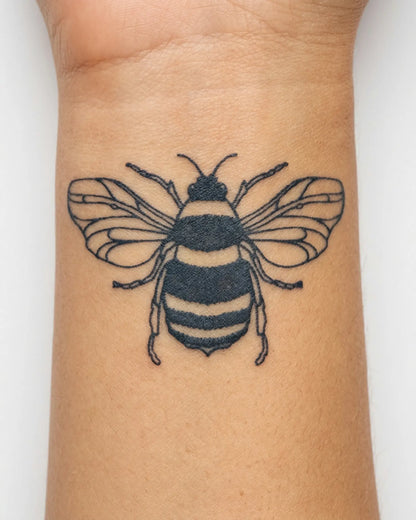 INKY Bumblebee semi-permanent tattoo applied on a woman – 2 x 2 in (4x4 cm) design, realistic ink look, lasts 10 days