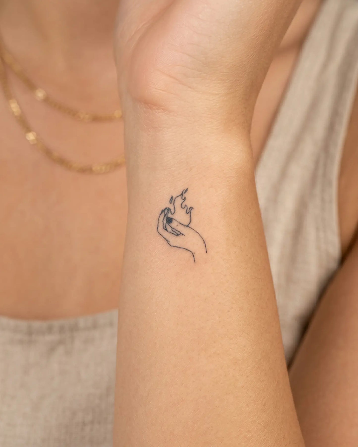 INKY Fire Hand semi-permanent tattoo applied on a woman – 0.5 x 0.5 in (1x1 cm) design, realistic ink look, lasts 10 days
