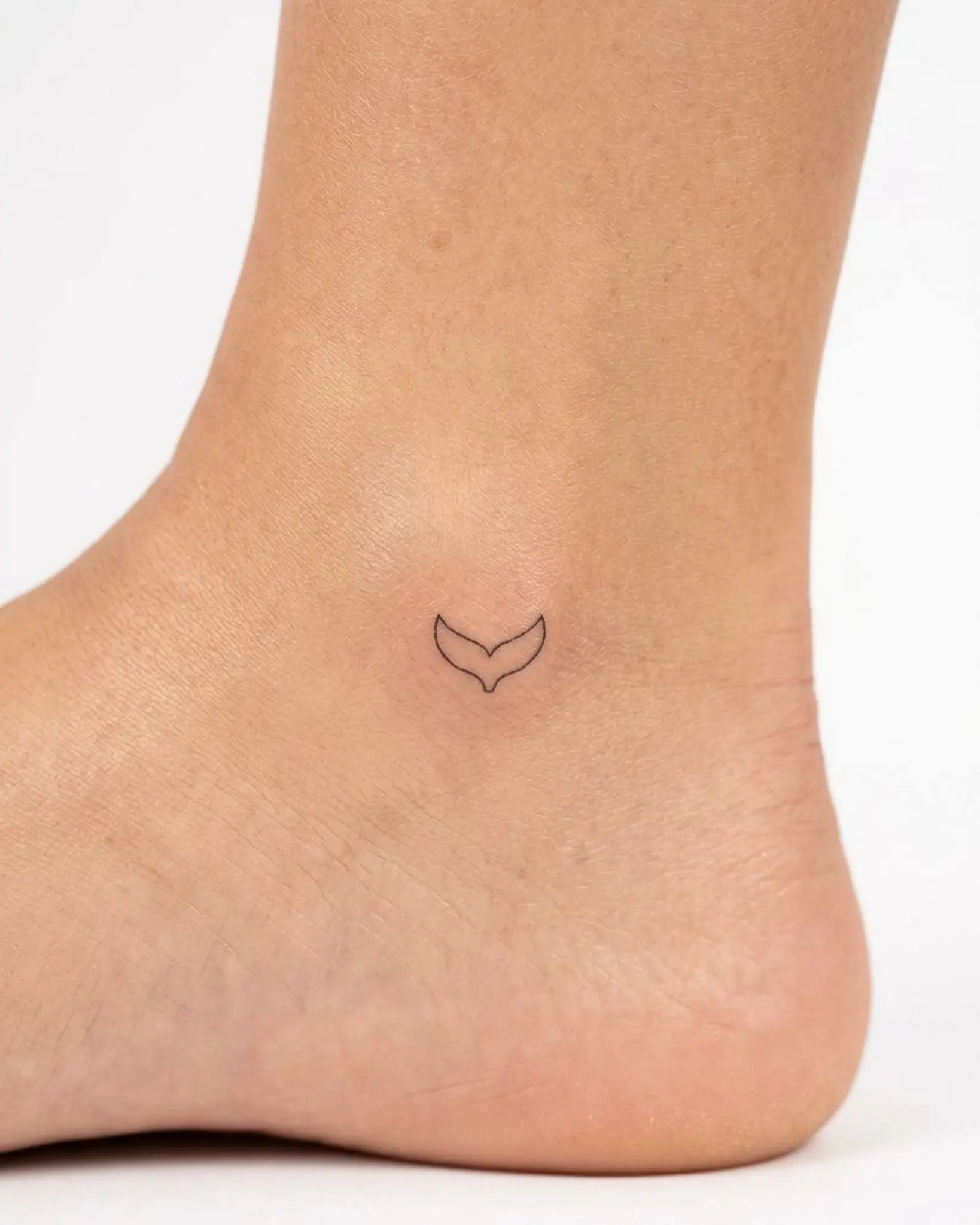 INKY Whale Tail semi-permanent tattoo applied on a woman – 0.5 x 0.5 in (1x1 cm) design, realistic ink look, lasts 10 days