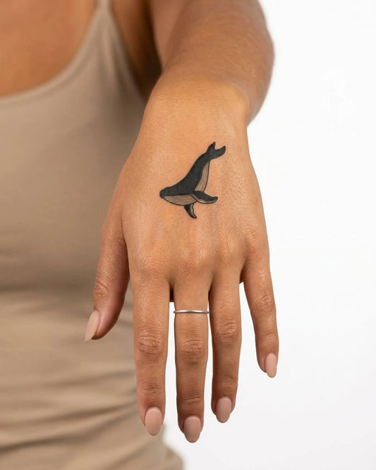 INKY Black Whale semi-permanent tattoo applied on a woman – 2 x 2 in (4x4 cm) design, realistic ink look, lasts 10 days