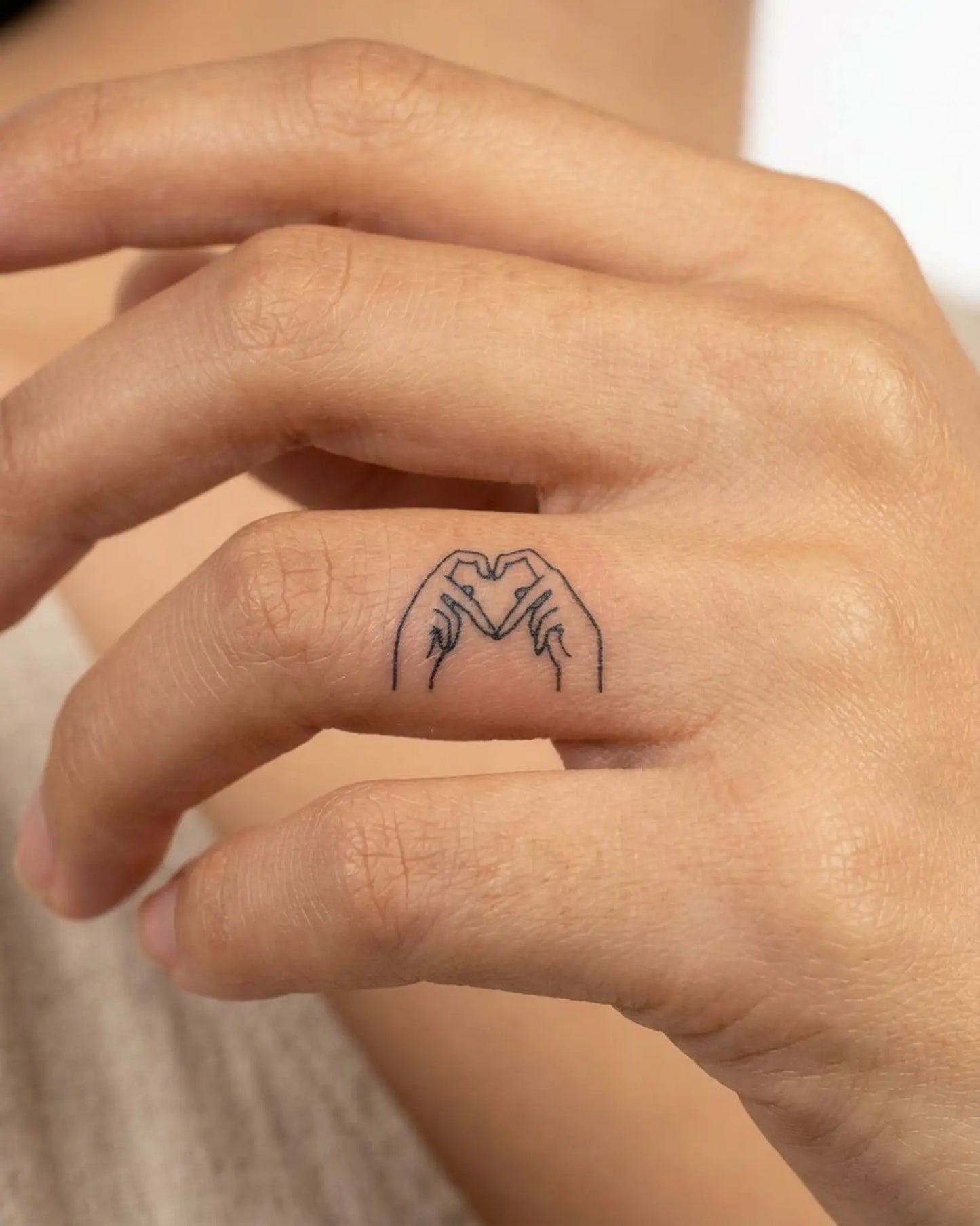 INKY Heart Hands semi-permanent tattoo applied on a woman – 0.5 x 0.5 in (1x1 cm) design, realistic ink look, lasts 10 days