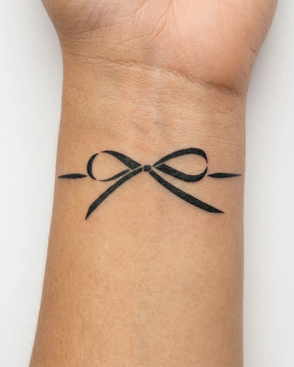 INKY Tied Bow semi-permanent tattoo applied on a woman – 2 x 2 in (4x4 cm) design, realistic ink look, lasts 10 days