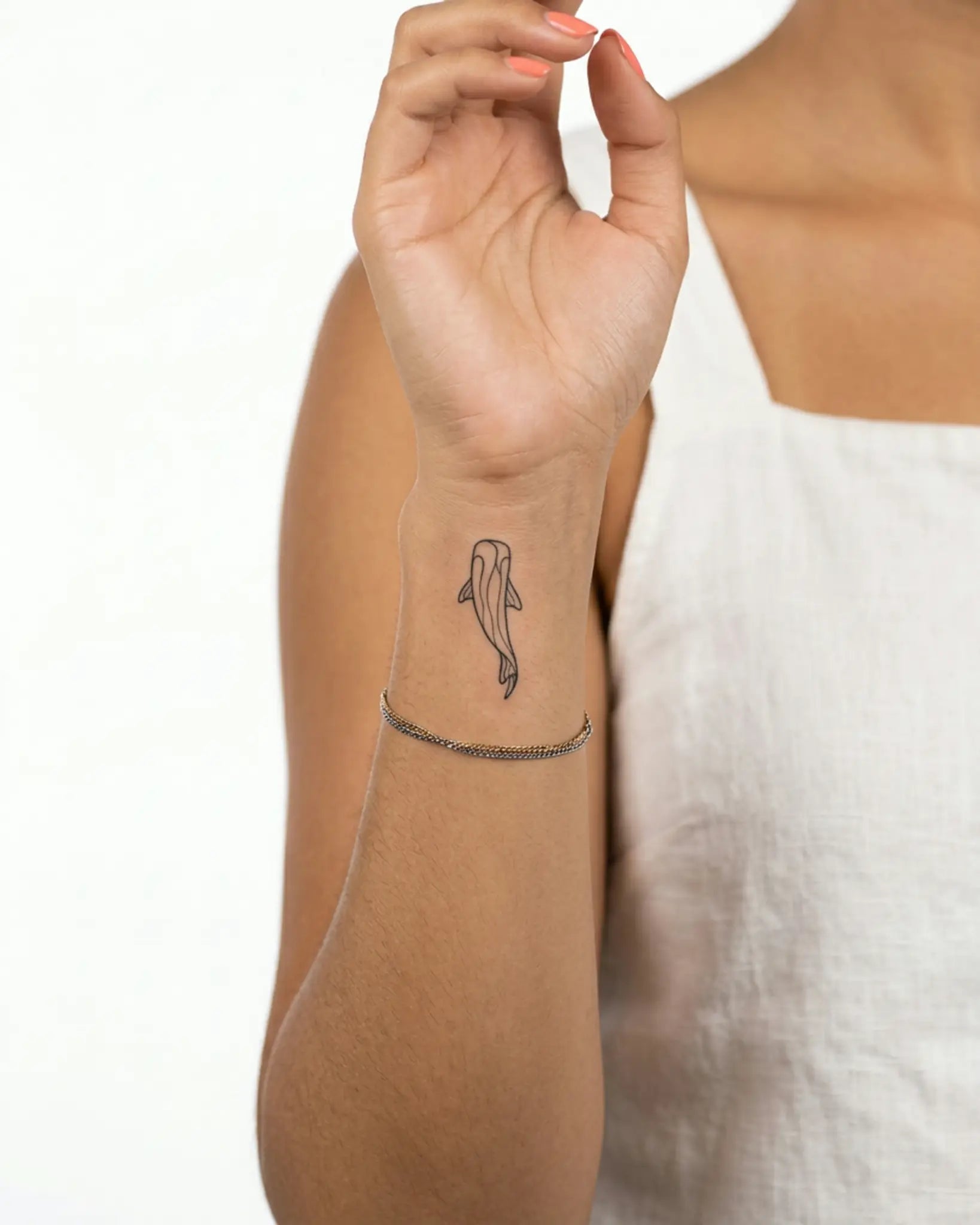 INKY Fish Flow semi-permanent tattoo applied on a woman – 2 x 2 in (4x4 cm) design, realistic ink look, lasts 10 days