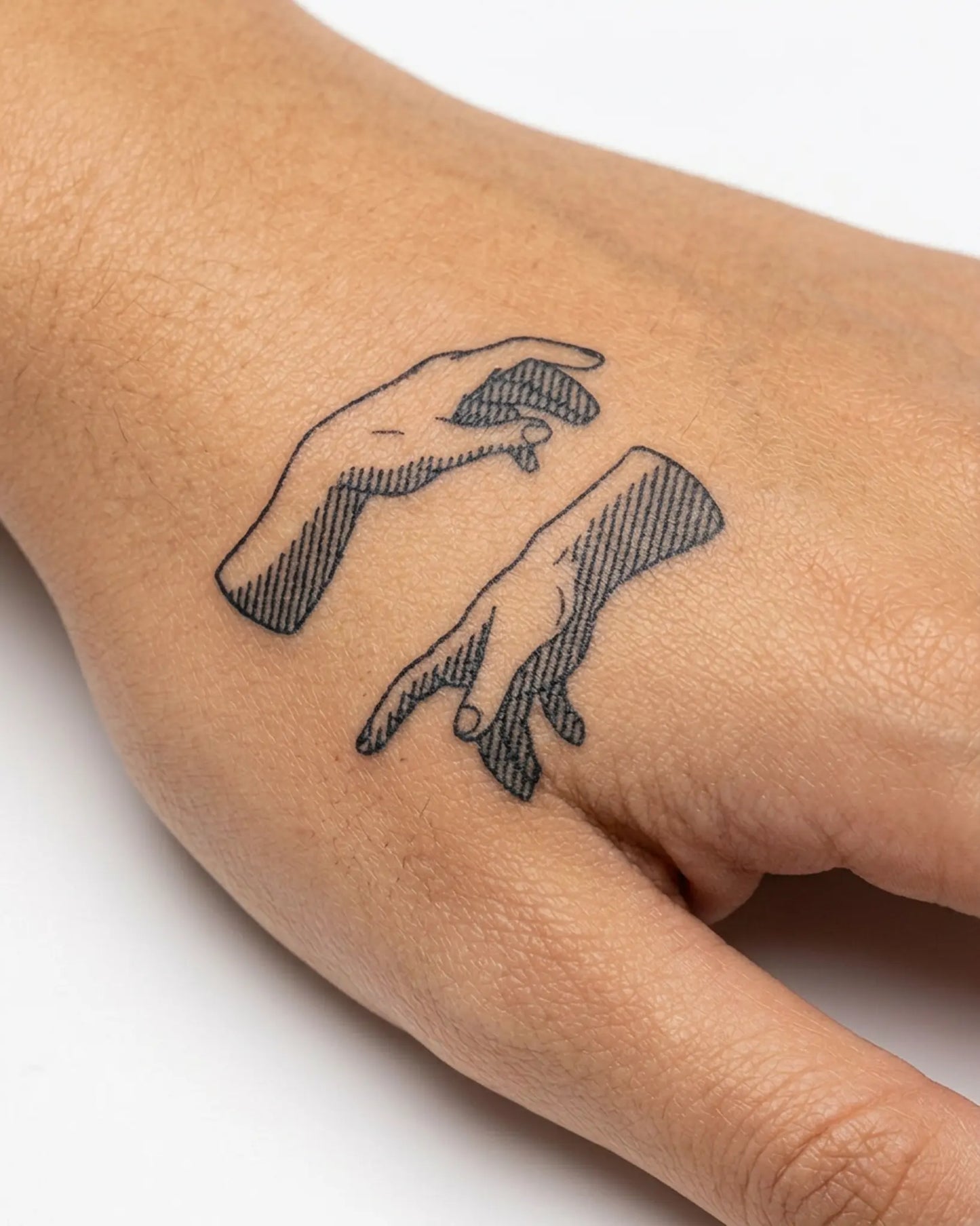 INKY Reach Out semi-permanent tattoo applied on a woman – 2 x 2 in (4x4 cm) design, realistic ink look, lasts 10 days