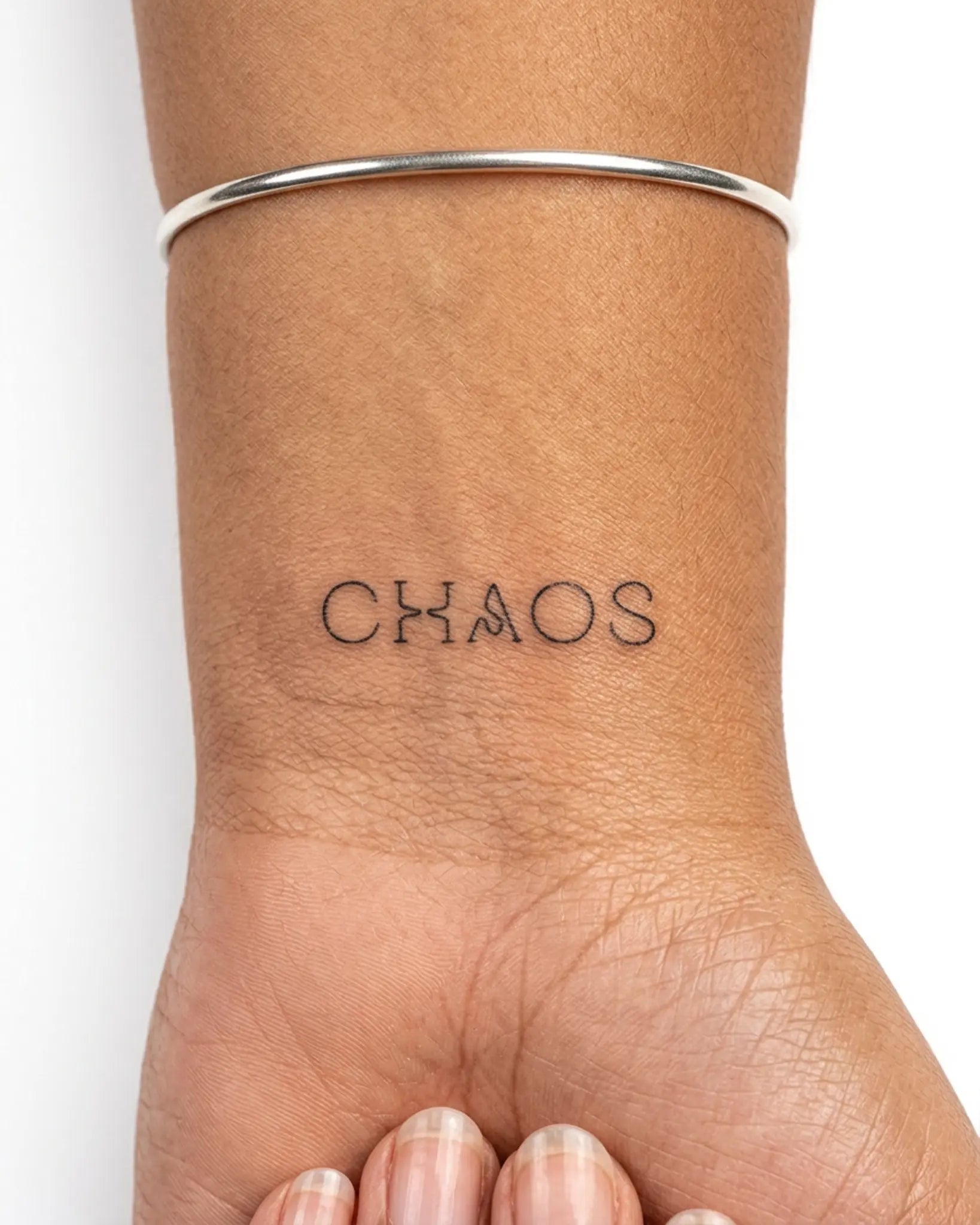 INKY Chaotic Word semi-permanent tattoo applied on a woman – 2 x 2 in (4x4 cm) design, realistic ink look, lasts 10 days