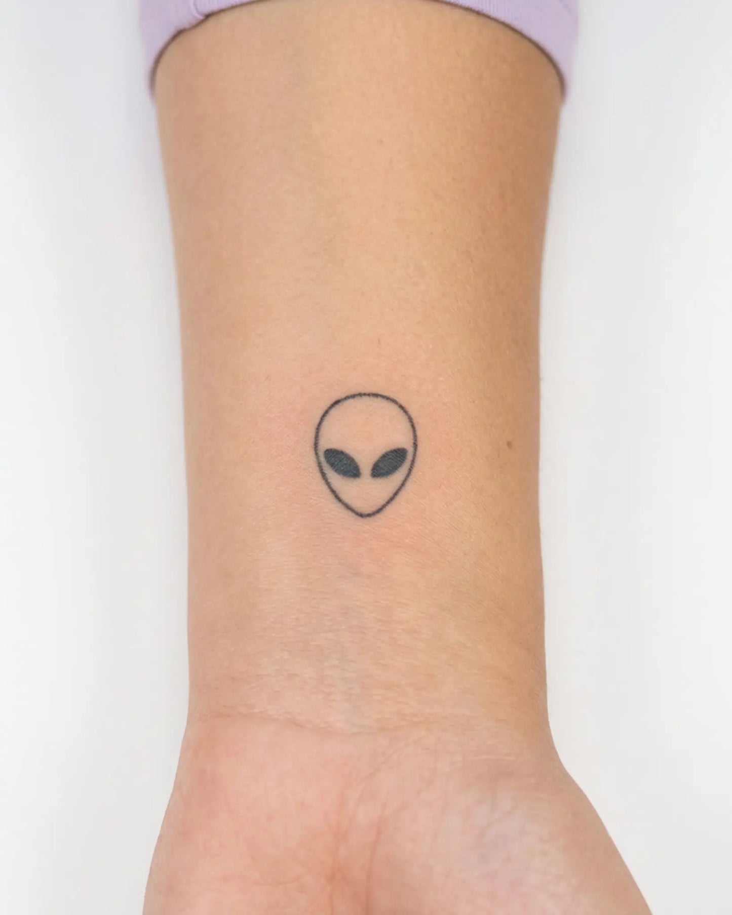 INKY Alien Head semi-permanent tattoo applied on a woman – 0.5 x 0.5 in (1x1 cm) design, realistic ink look, lasts 10 days