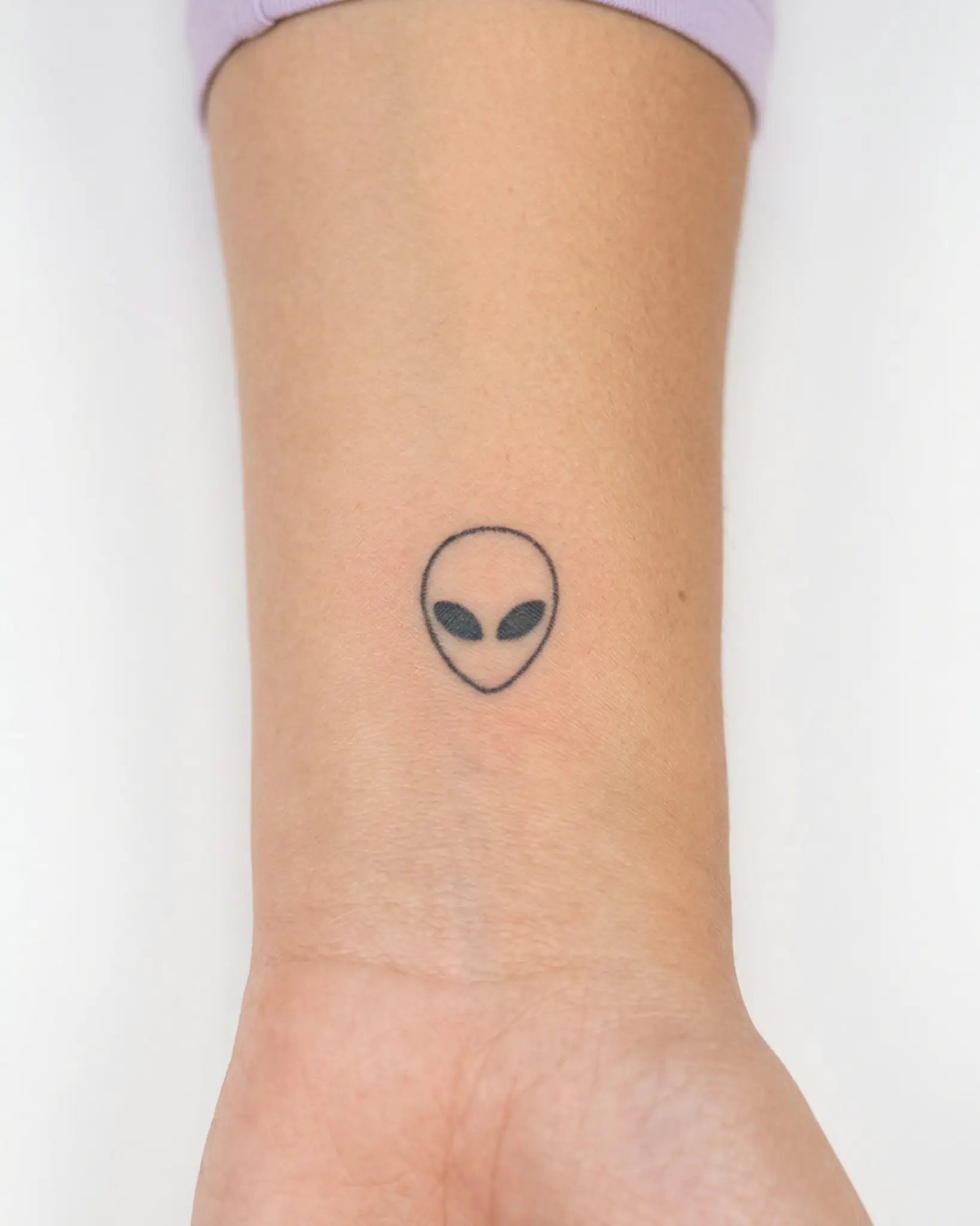 INKY Alien Head semi-permanent tattoo applied on a woman – 0.5 x 0.5 in (1x1 cm) design, realistic ink look, lasts 10 days