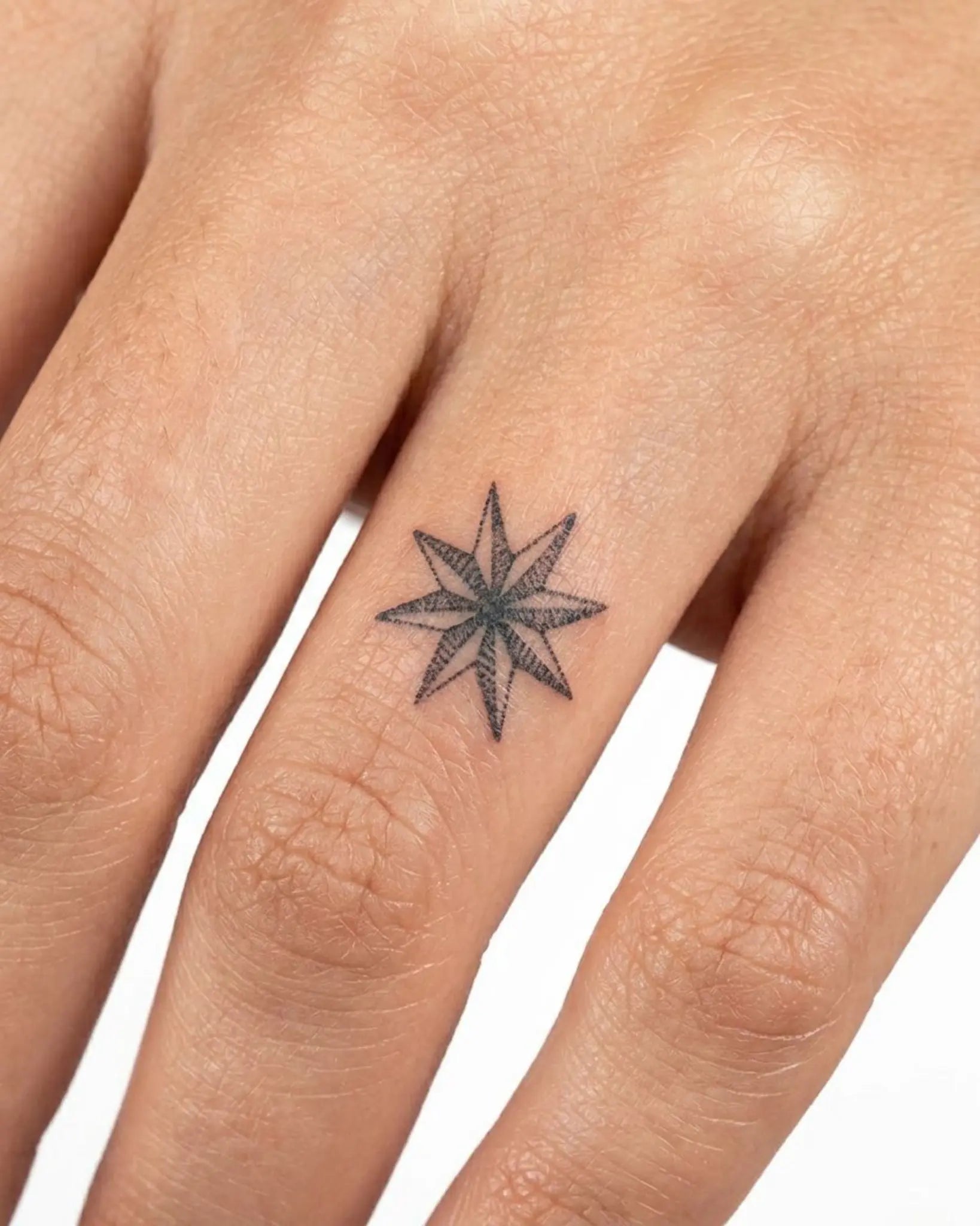 INKY North Star semi-permanent tattoo applied on a woman – 0.5 x 0.5 in (1x1 cm) design, realistic ink look, lasts 10 days