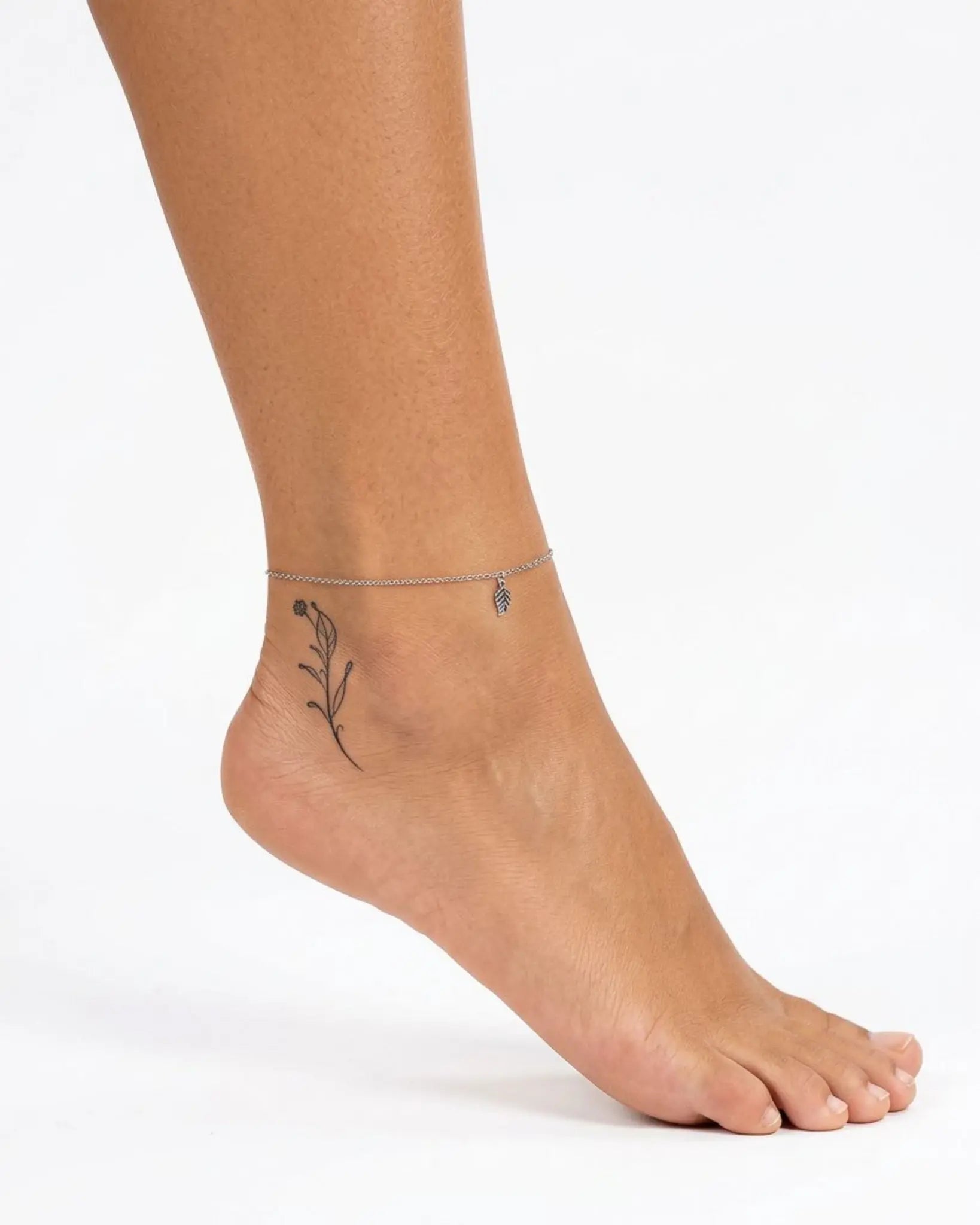 INKY Floral Stem 3 semi-permanent tattoo applied on a woman – 2 x 2 in (4x4 cm) design, realistic ink look, lasts 10 days