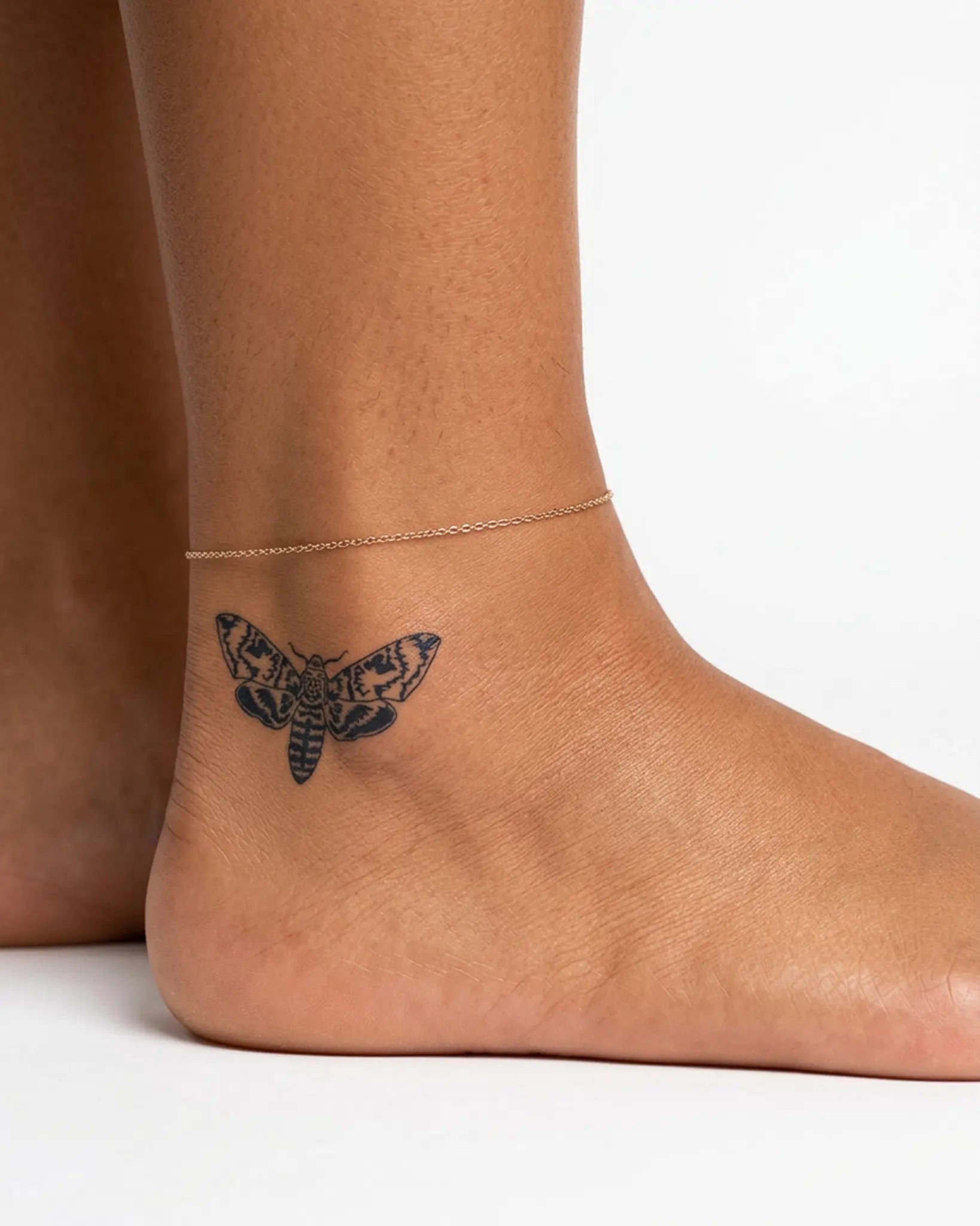 INKY Death Moth semi-permanent tattoo applied on a woman – 2 x 2 in (4x4 cm) design, realistic ink look, lasts 10 days