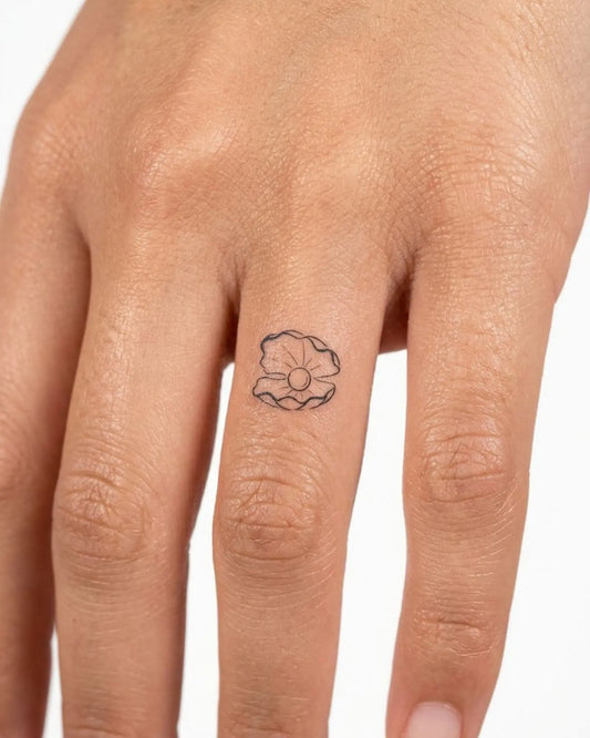 INKY Pearl Shell semi-permanent tattoo applied on a woman – 0.5 x 0.5 in (1x1 cm) design, realistic ink look, lasts 10 days