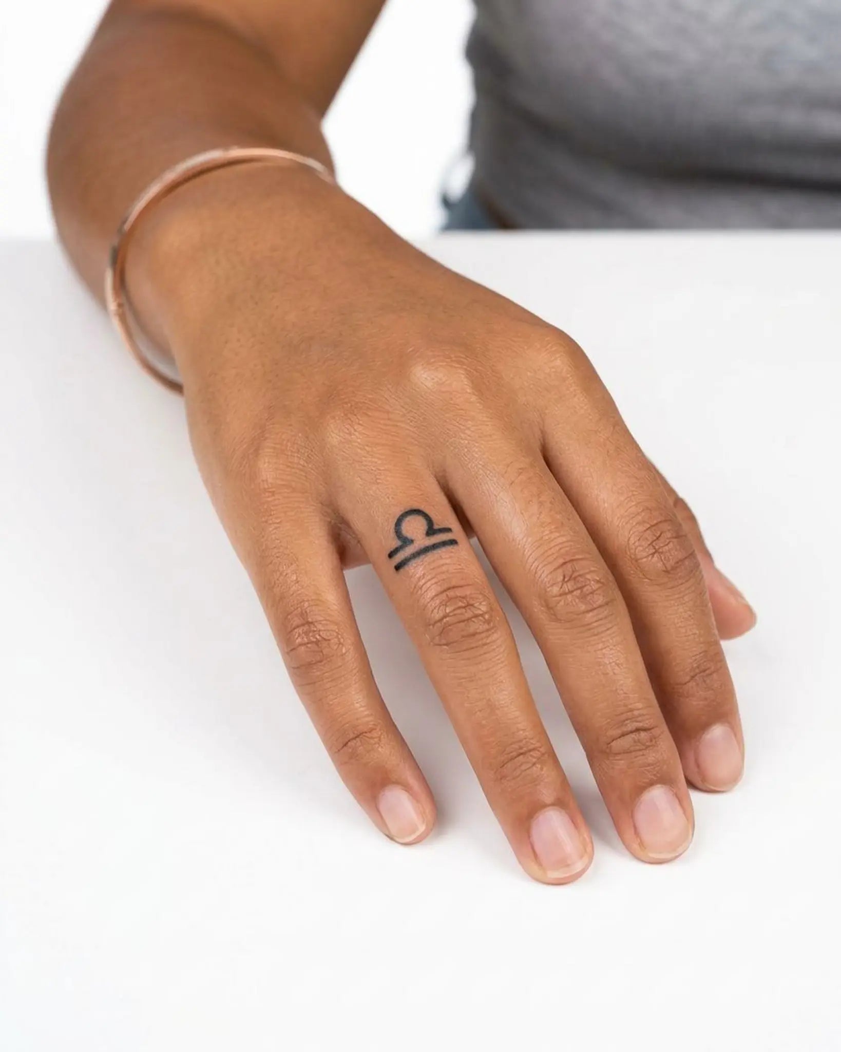 INKY Libra semi-permanent tattoo applied on a woman – 0.5 x 0.5 in (1x1 cm) design, realistic ink look, lasts 10 days
