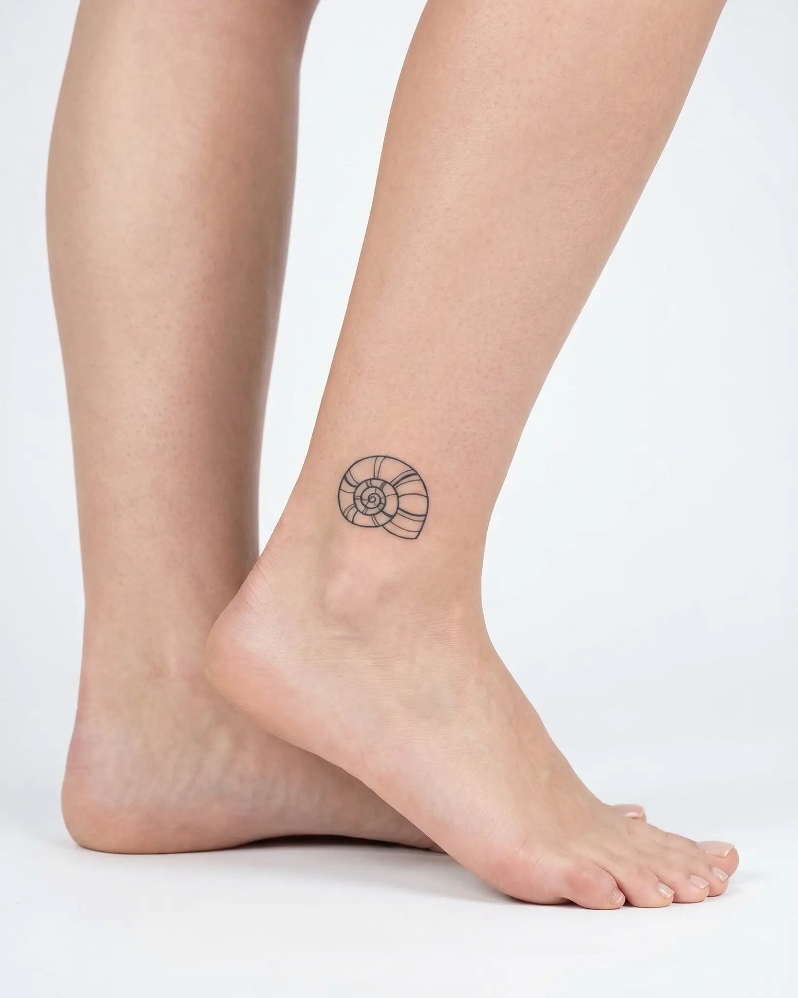 INKY Nautilus semi-permanent tattoo applied on a woman – 2 x 2 in (4x4 cm) design, realistic ink look, lasts 10 days
