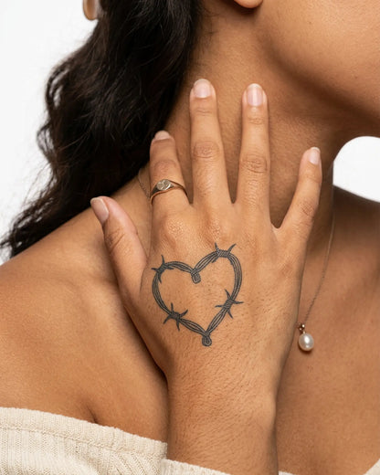 INKY Barbed Heart semi-permanent tattoo applied on a woman – 2 x 2 in (4x4 cm) design, realistic ink look, lasts 10 days