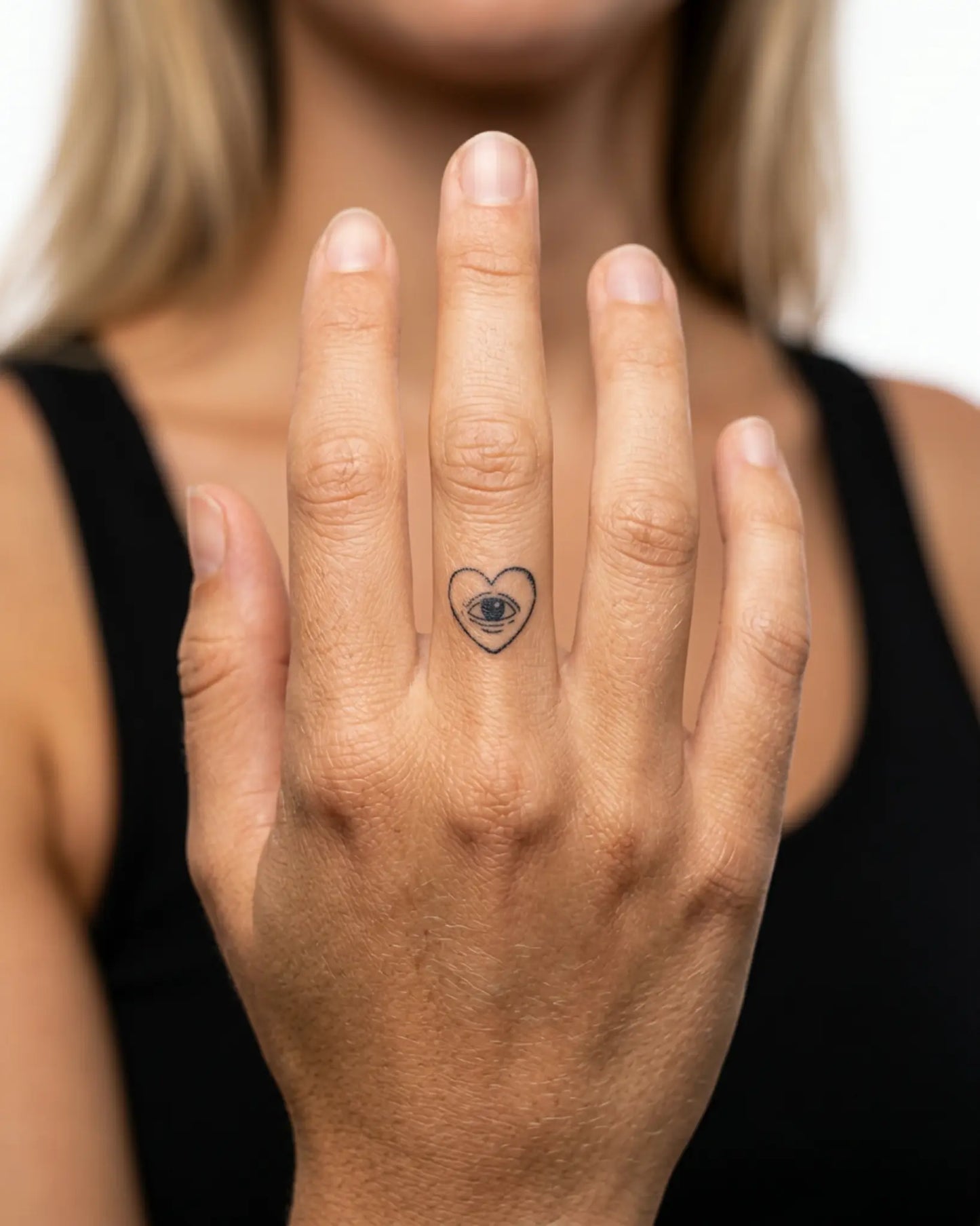 INKY Heart Eye semi-permanent tattoo applied on a woman – 0.5 x 0.5 in (1x1 cm) design, realistic ink look, lasts 10 days