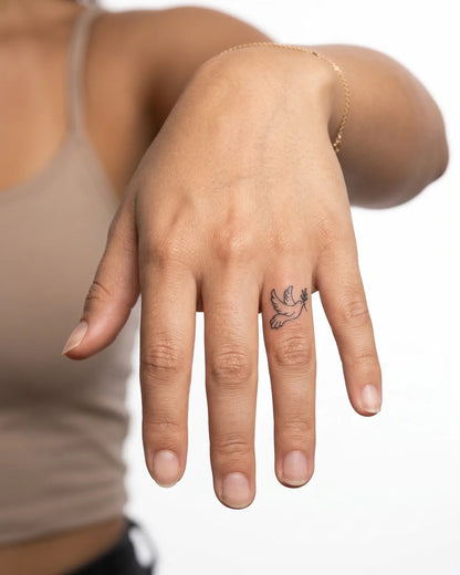 INKY Peace Dove semi-permanent tattoo applied on a woman – 0.5 x 0.5 in (1x1 cm) design, realistic ink look, lasts 10 days