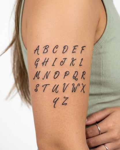 INKY Script A-Z semi-permanent tattoo applied on a woman – 3 x 3 in (7x7 cm) design, realistic ink look, lasts 10 days